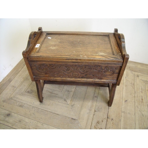 381 - Carved oak stool with lift up top revealing fitted interior with various sewing items (width 56cm)