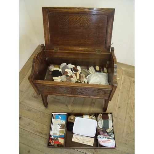 381 - Carved oak stool with lift up top revealing fitted interior with various sewing items (width 56cm)