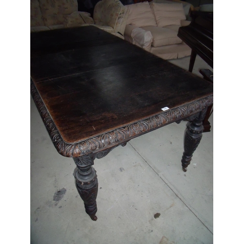 459 - Victorian dark oak extending dining table with two additional leaves and carved border detail, on tu... 