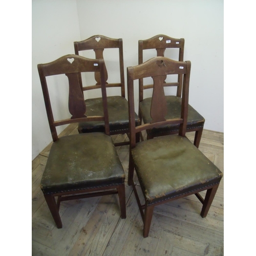 371 - Set of four early 20th C oak dining chairs with leather upholstered seats and carved heart shaped de... 