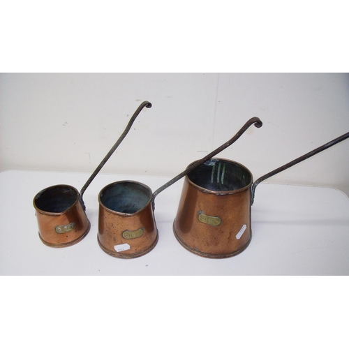 63 - Set of three copper cider measures with wrought metal handles