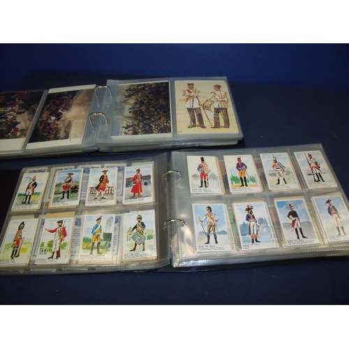 128 - Album of military related postcards depicting various uniforms, battles, regiments etc, and an album... 