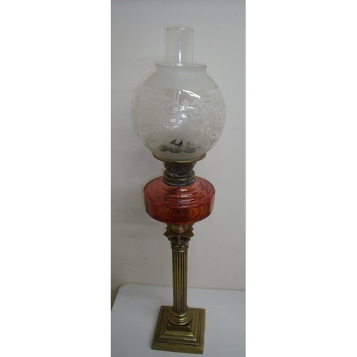 95 - Brass Corinthian column oil lamp with red glass reservoir and etched shade (80cm high)