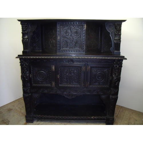 292 - 18th C and later elaborately carved dark oak court cupboard, with raised pediment above central cupb... 