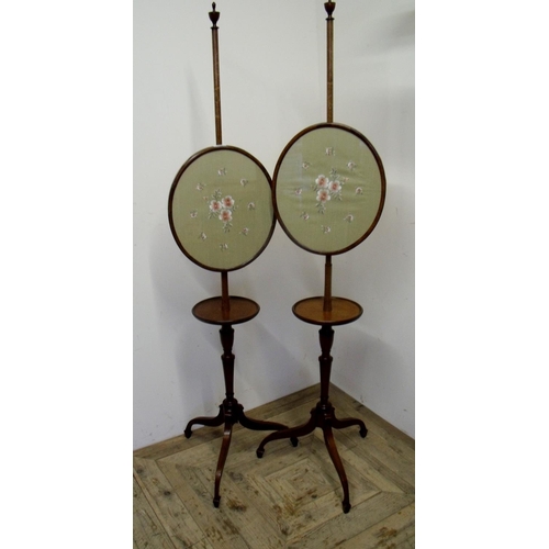 290 - Pair of 19th/20th C mahogany pole screens with circular shelf under oval panels depicting floral nee... 