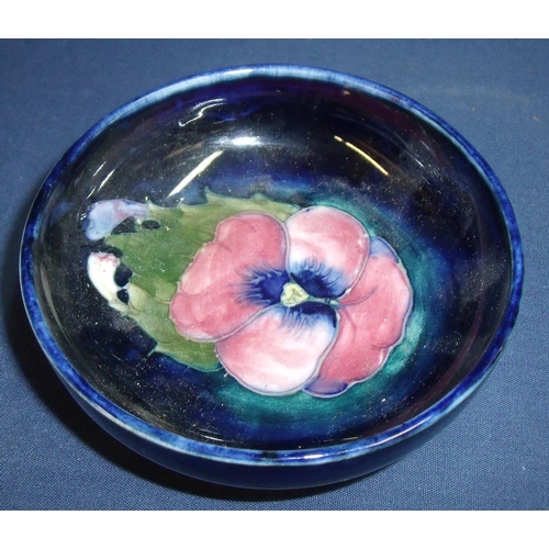 22 - signed William Moorcroft shallow bowl on raised base with central pansy type flower (11.5cm x 4cm)