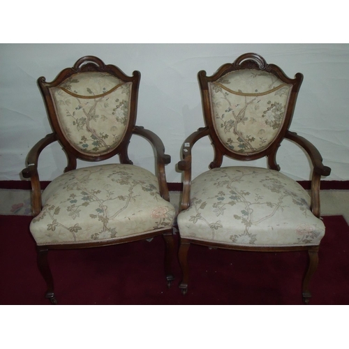 302 - A pair of Victorian walnut framed armchairs with upholstered seats and backs