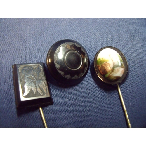 150 - Two Whitby jet pins one with rectangular panel carved with rose the other with inset painted porcela... 