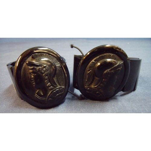 153 - Pair of similar Whitby jet bracelets with large cameo profile panel depicting a Greek style warriors... 