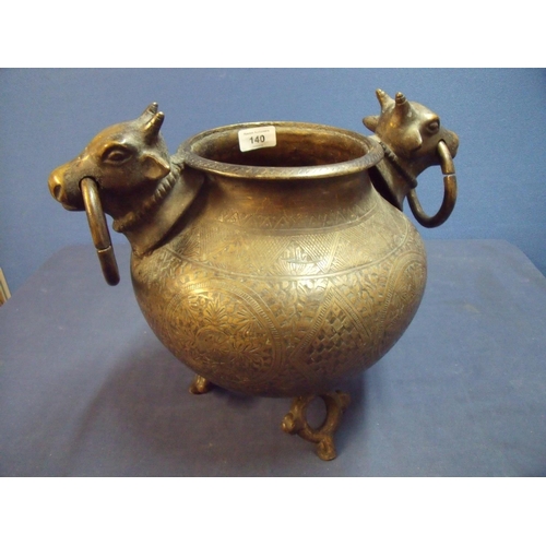 140 - Large Eastern style bronze pot/sensor with twin cows head and bull ring handles with engraved floral... 