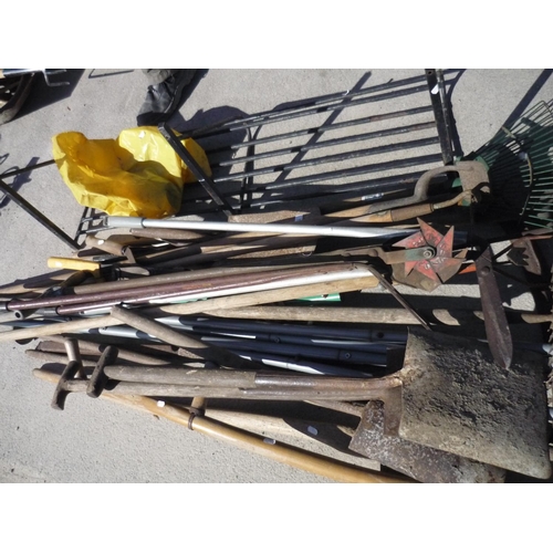 123 - Large selection of garden tools including spades, shovels, rakes, a scythe, metal saddle rack for a ... 
