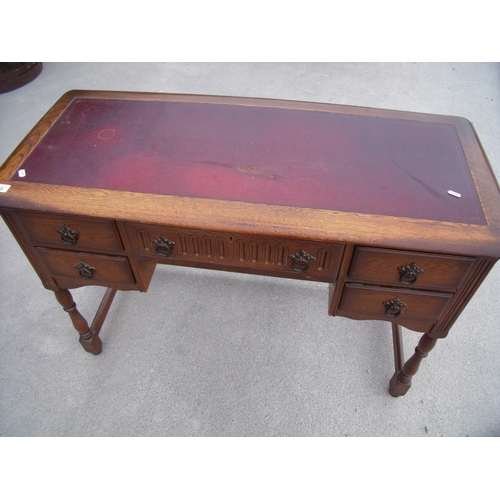 433 - Reproduction oak writing table with inset top and central drawer flanked by four short drawers, on t... 