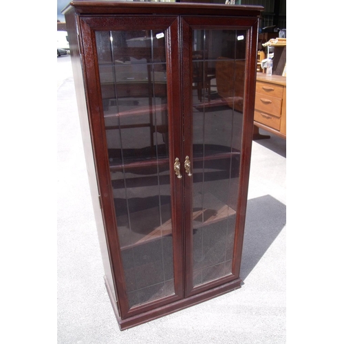 353 - Modern mahogany effect cabinet enclosed by two glazed doors (63cm x 33cm x 128cm)