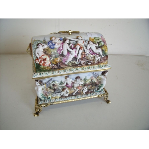 8 - Capodimonte rectangular ceramic casket with gilt metal claw feet and domed lift off lid, with lion m... 