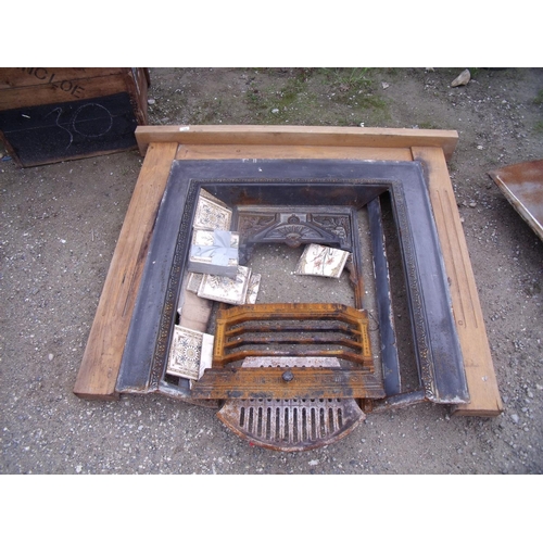 135 - Cast iron fire surround with wooden mantel and a number of decorative tiles