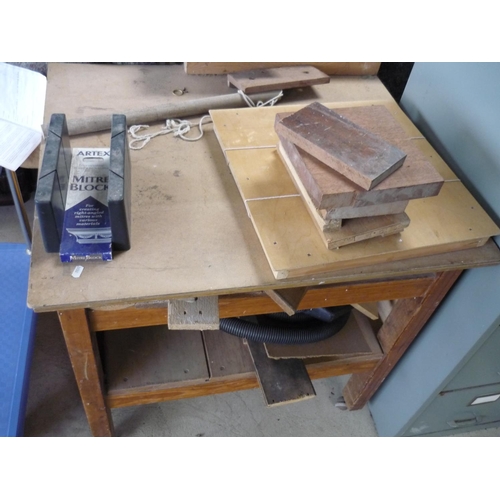 37 - A wooden work bench on wheels with various pieces of wood for measuring