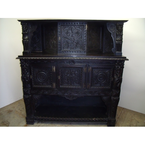 282 - 18th C and later elaborately carved dark oak court cupboard, with raised pediment above central cupb... 