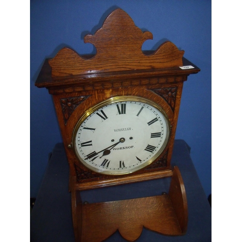 137 - Wheeler of Worksop carved oak cased double fusee wall mounted bracket clock in light oak case, with ... 