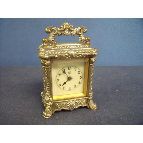 162 - Silver plated repeating carriage type clock with ornate case, with floral detail and white enamel di... 