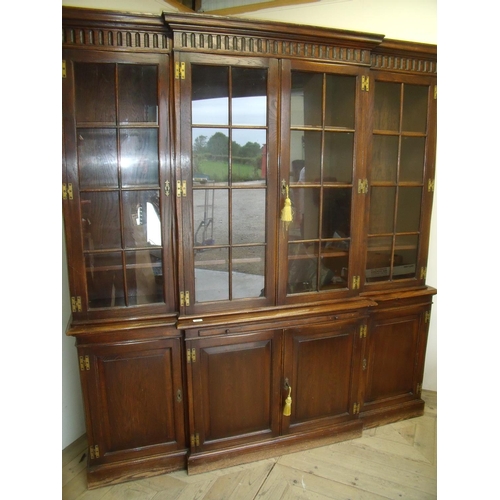 275 - Quality modern oak breakfront bookcase with four glazed doors above central slide and four panelled ... 