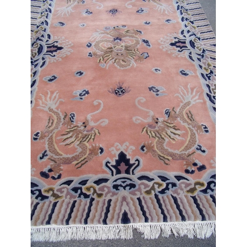 311 - Large Chinese beige ground and dragon pattern woollen rug (290cm x 184cm)