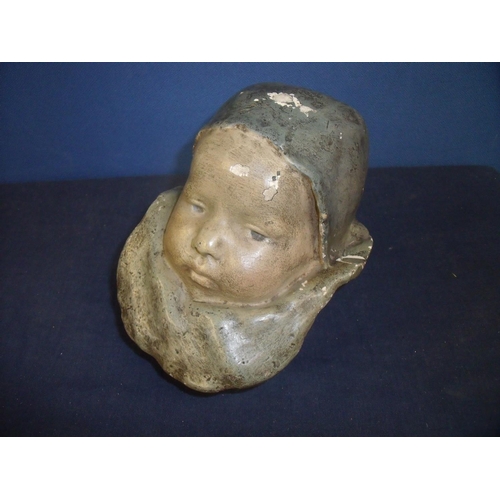 33 - Unusual early 20th C plaster cast figure of a babies head wearing bonnet and bib (16cm high)