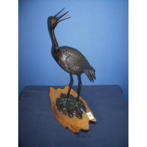 74 - Early 20th C Japanese bronze figure of a crane, mounted on later wooden base (height 49cm)
