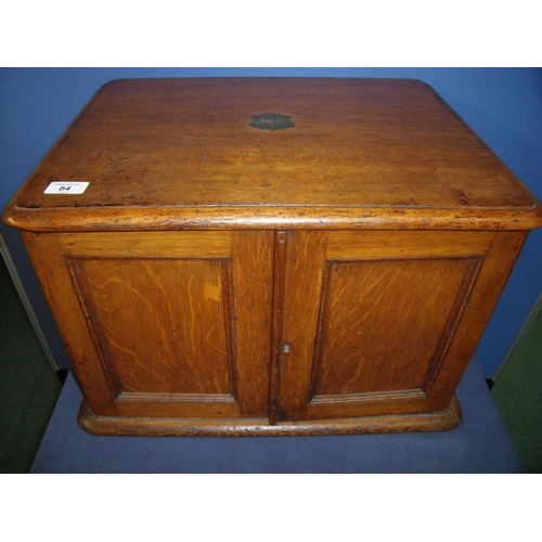 84 - Edwardian oak table box with inset brass carry handles, enclosed by two panelled cupboard doors reve... 