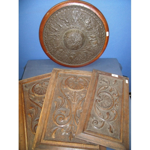 38 - Three 19/20th C carved oak panels and an embossed bronze circular type shield depicting various batt... 