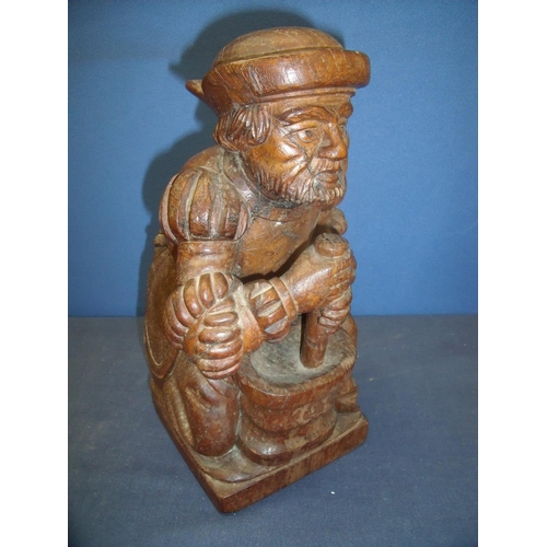 55 - Carved oak figure of a alchemist/apothecarist kneeling at pestle and mortar (32cm high)
