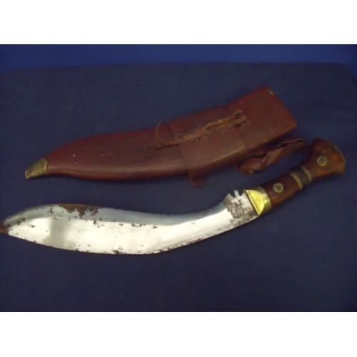 1 - Large Kukri knife with 14 inch blade, brass mounts and two piece wooden grip, with traces of various... 