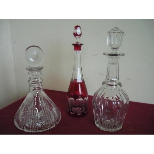 76 - Cranberry and clear cut glass decanter, a heavy cut glass decanter and another (3)