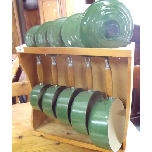 65 - Set of five Le Creuset green enamel sauce pans complete with wall rack