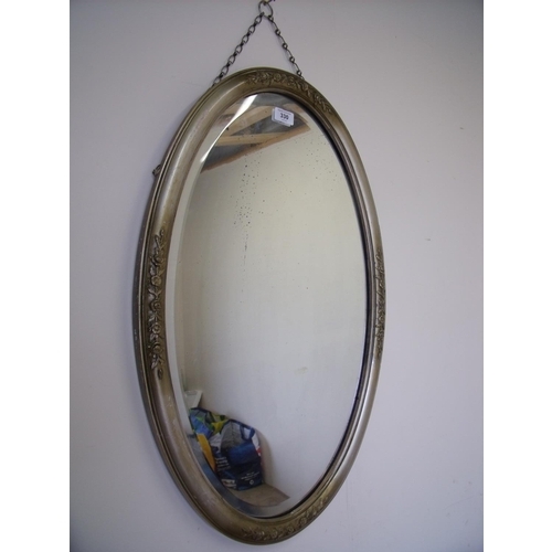 330 - Oval bevel edged mirror in old gold frame set with garlands of roses