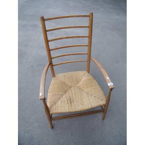 124 - Early 20th C light elm ladder back low rush seated armchair