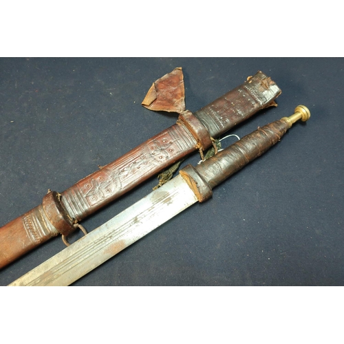 224 - African Tuareg Sword with 31 inch blade, leather grip, brass pommel and leather scabbard with swolle... 