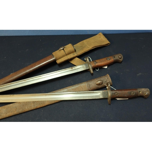 271 - Two British 1907 bayonets complete with scabbards, one with canvas webbing frog, with various stampe... 