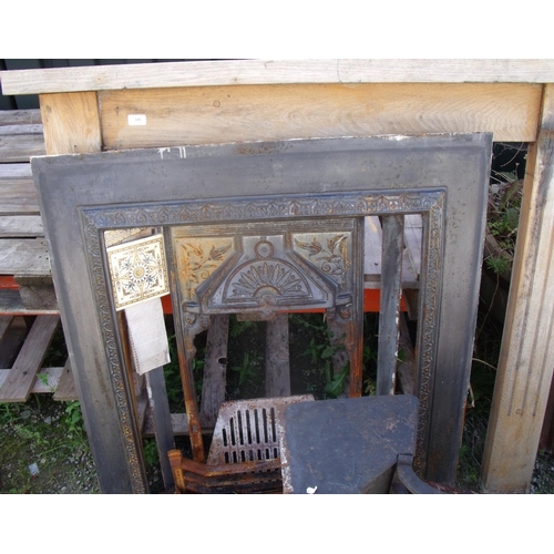 145 - Cast iron fire surround with wooden mantel and a number of decorative tiles