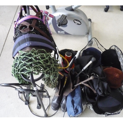 57 - Collection of horse tack including boots (size 5), four riding helmets, bridles, saddle holder, hay ... 
