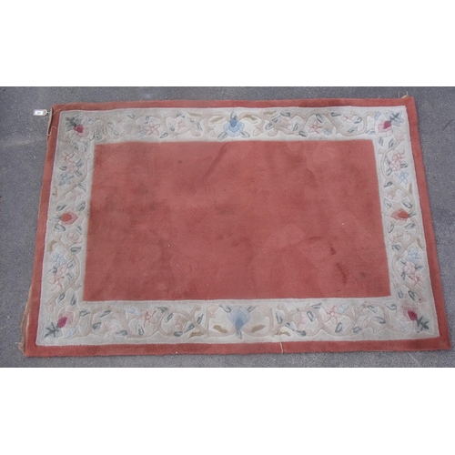 183 - Chinese embossed washed woollen rug, terracotta ground with floral pattern border (180cm x 122cm)