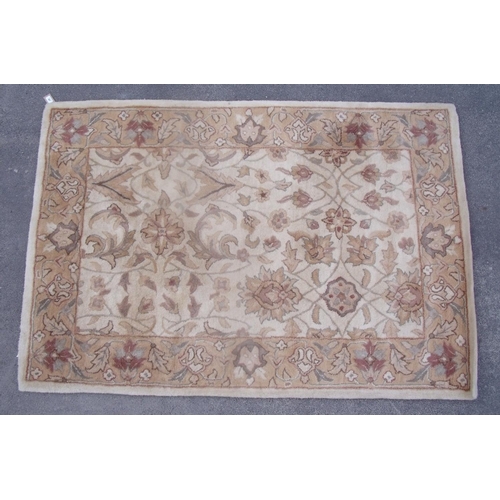 389 - Traditional pattern wool rug, beige ground with stylised floral pattern and border (183cm x 125cm)