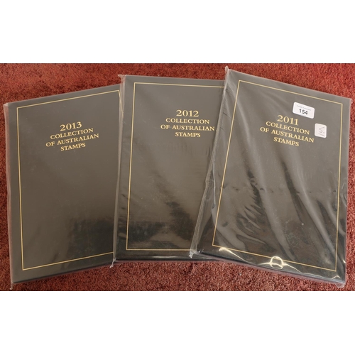 154 - Three Australian executive black leather postage yearbooks 2011 - 2013 with mint stamps unopened as ... 