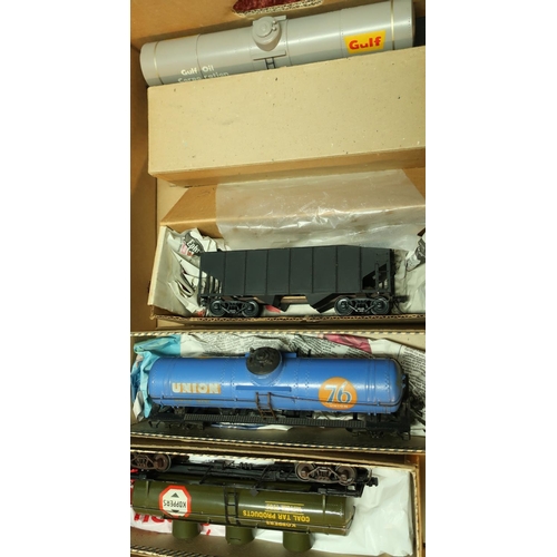 224 - Six boxed and one unboxed American style O gauge rolling stock including open wagons, tankers, coal ... 