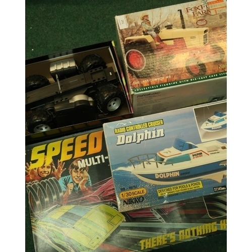 241 - Boxed Dolphin Remote Control Boat, chassis for remote control car, die-cast tractor and a boxed Spee... 