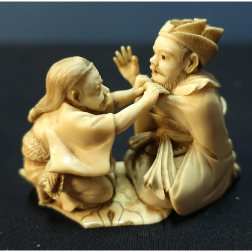 348 - 19th C finely carved Japanese ivory group of eldery gentleman being dressed by a lady, both in kneel... 