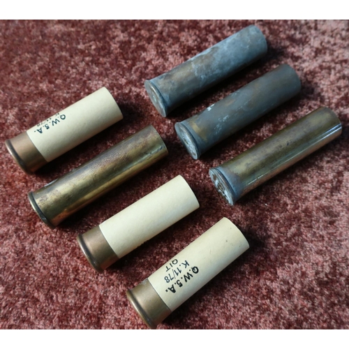 668 - Box with four solid brass 4 bore shotgun cartridge casings and three similar paper casings