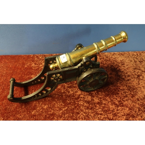 79 - Brass fire side cannon with 11 1/2 inch staged barrel and cast metal carriage