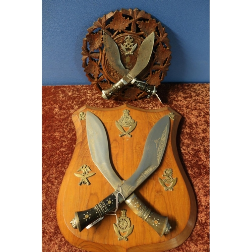 409 - Carved wood wall plaque mounted with two Kukri type knives with a crowned Staffordshire Gurkha badge... 