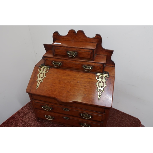 27 - Edwardian mahogany miniature bureau with two drawers above lift up slope front with ornate brass str... 