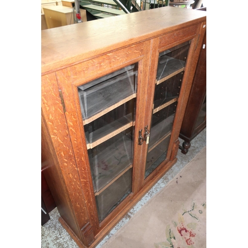 287 - Edwardian light oak bookcase enclosed by two bevel edged glazed cupboard doors (103cm x 30cm x 119cm... 